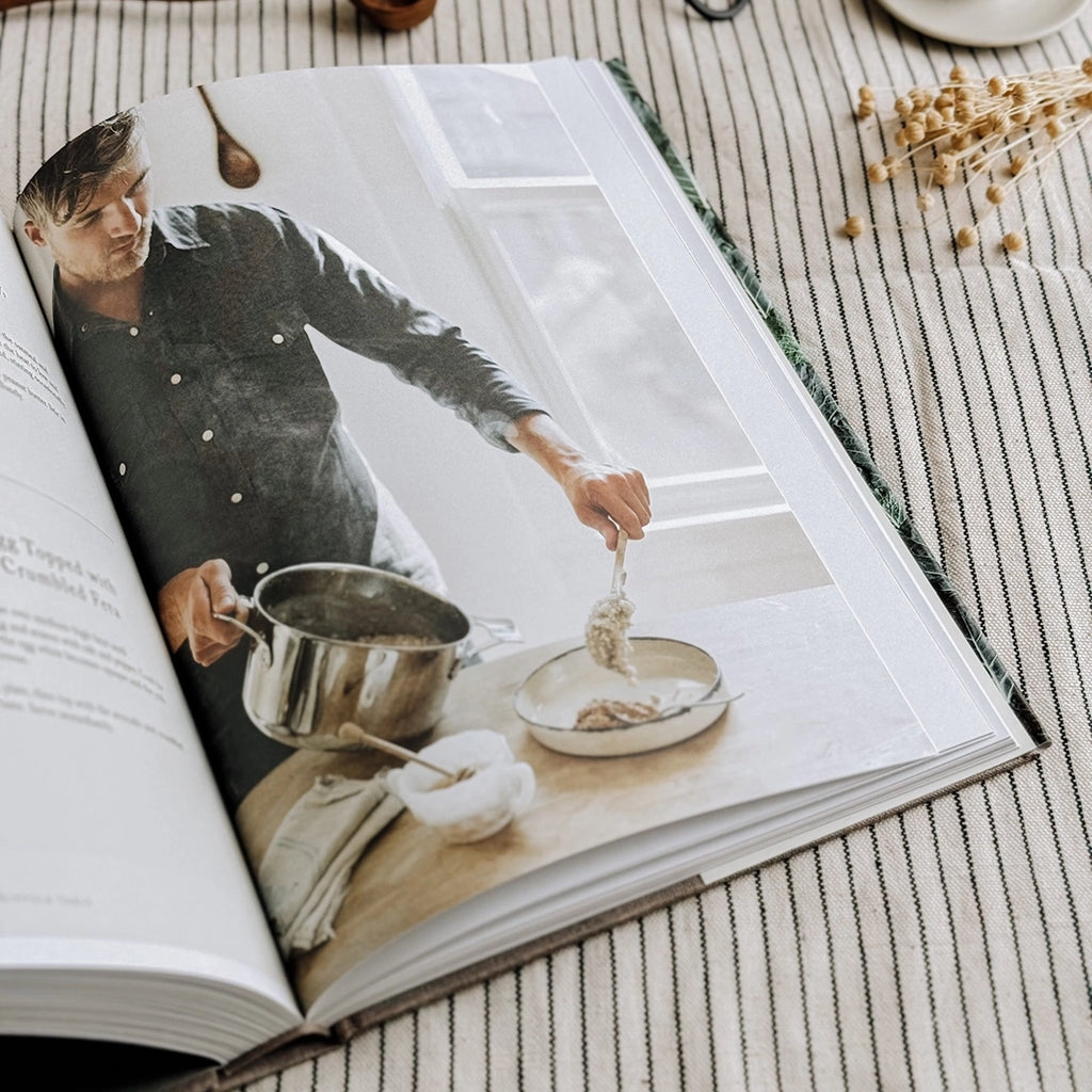 One of the inside pages of The Kinfolk Table Recipes for Small Gatherings Cook Book. The book is open on a striped table cloth. byFoke