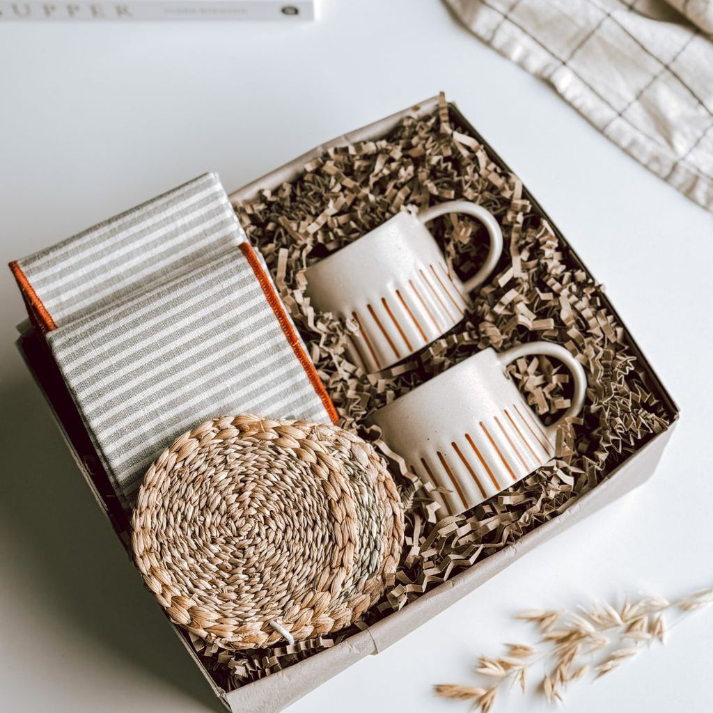 An open byFoke Gift Box, with 2 striped mugs, 2 natural woven coasters and a pair of striped cotton napkins.