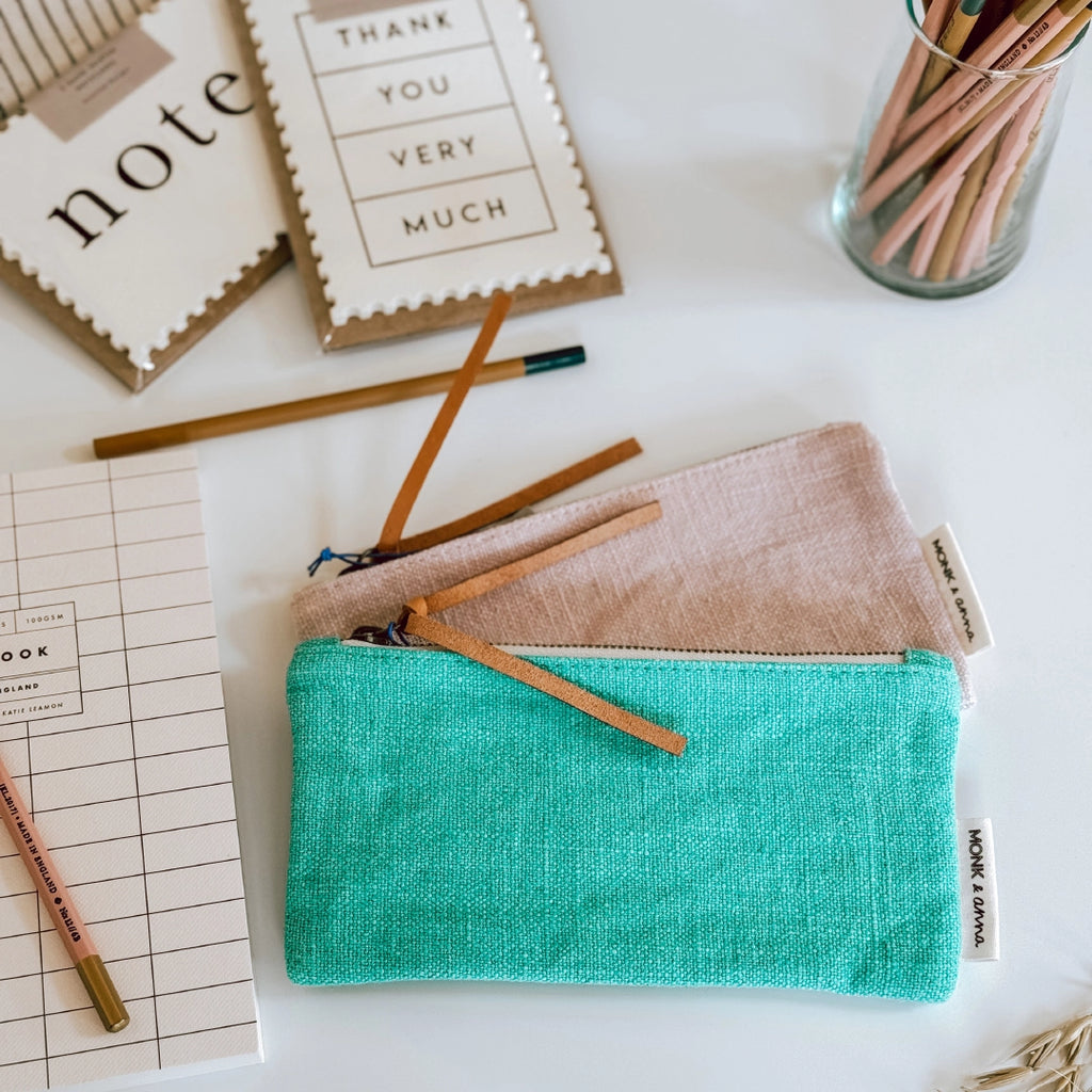 Two Monk & Anna linen pencil cases on a table in the byFoke studio with pencils and notecards in the background.