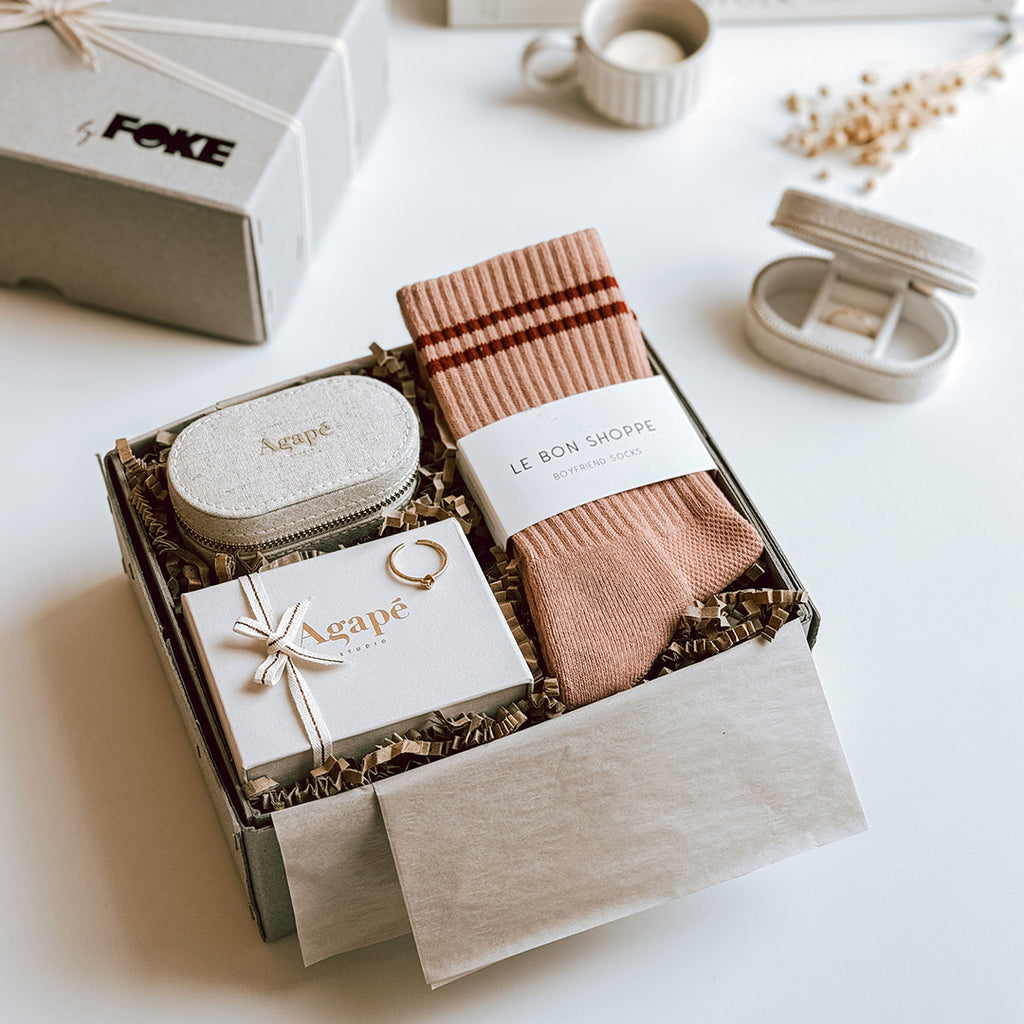 byFoke's Romy Luxury Gift Box laying open on a table with the lid in the background. Inside you can see an Agape gold ring, linen jewellery box and a pair of Le Bon Shoppe socks in Vintage Pink. 