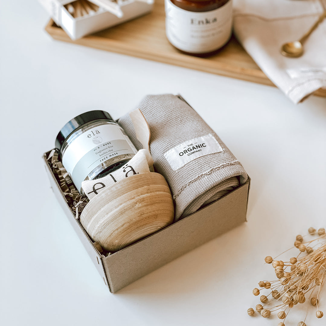 The byFoke Eve gift box containing the Ela Life Kaolin Clay Face Mask Set and Calm wash cloth by The Organic Company. The gift box is sitting on a white table.