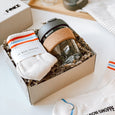 A byFoke gift box containing, a pair of stripy Le Bon Shoppe Girlfriend socks and a glass KeepCup with a khaki lid.