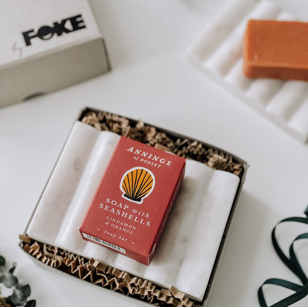 A carved marble soap dish in soft grey with a beautifully designed box of handmade soap from Dorset.